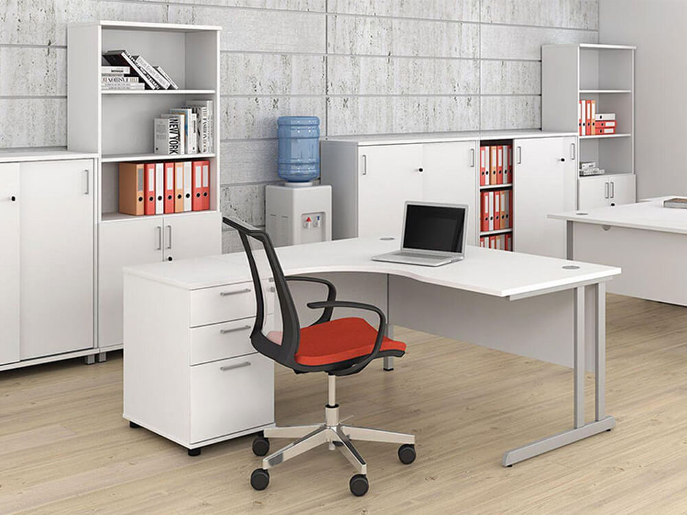 An office furnished with modern office furniture, including a corner desk as an attempt to implement different zoning strategies to cope with different temperature requirements.