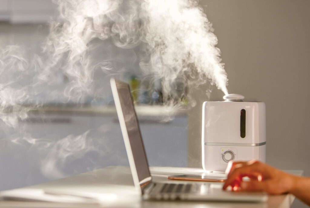 A professional working near an aroma oil diffuser, symbolising the use of pleasant scents in finance firms to create a relaxing atmosphere for clients.